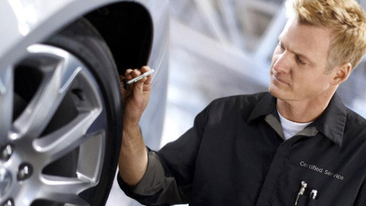 service technician checking tire on car