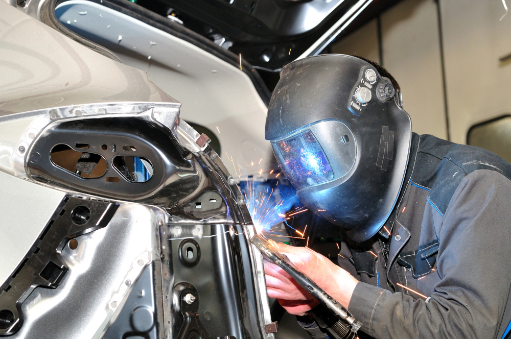 Auto body technician welding car